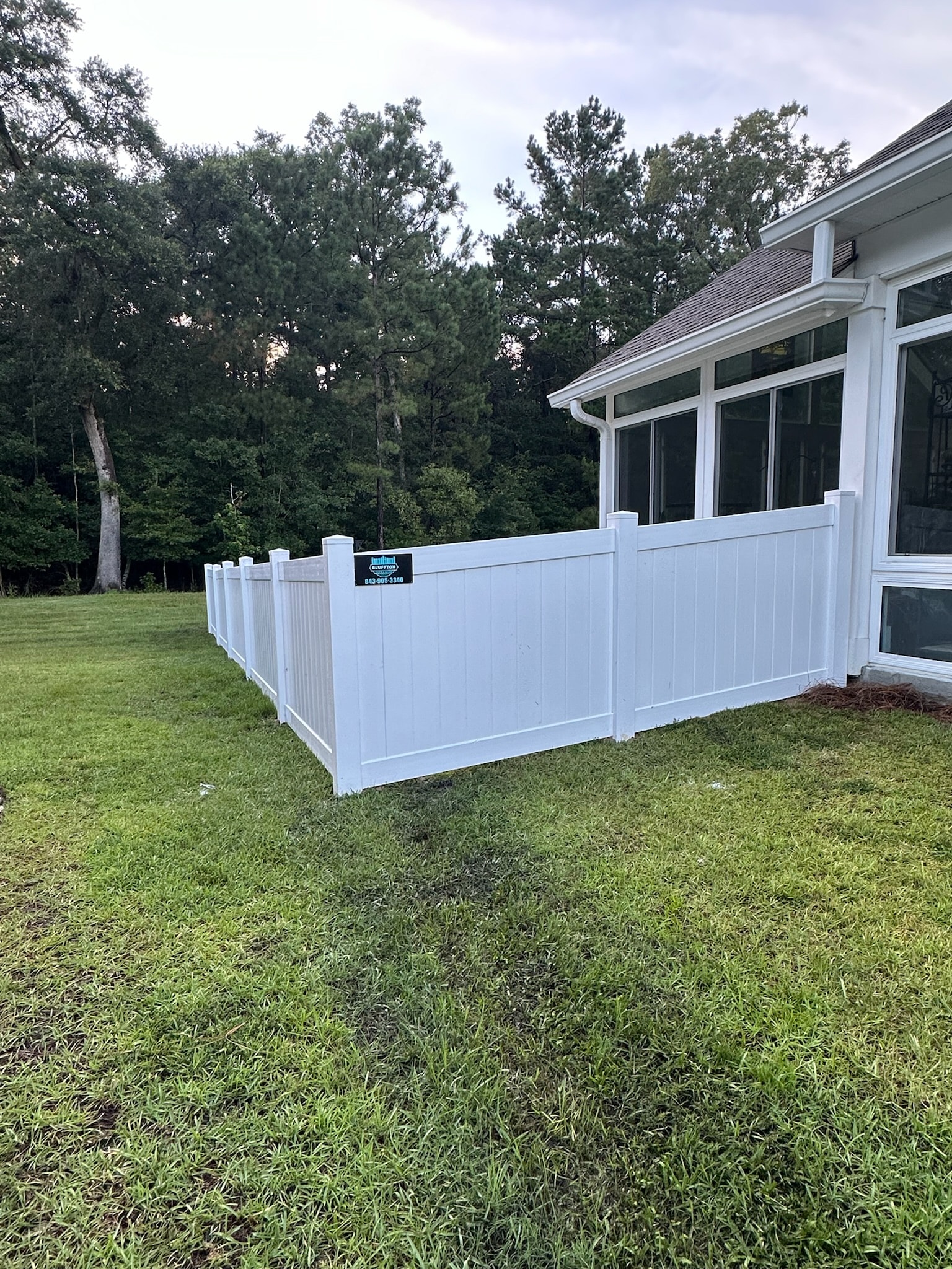White vinyl fence wrapping full backyard at sunset
